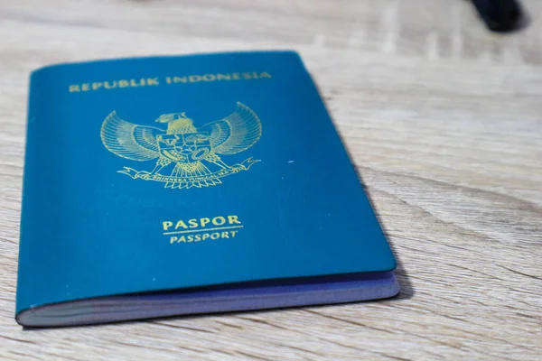 Indonesian green passport on a wooden table. This passport is an identity for Indonesian citizens who are going abroad.