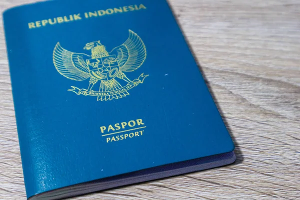 Indonesian green passport on a wooden table. This passport is an identity for Indonesian citizens who are going abroad.