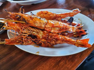 Ballı ızgara karides, lezzetli bir aromayla mükemmel dengelenmiş lezzetli ve tatlı bir tadı olan tipik bir Endonezya deniz ürünleri yemeği. Lokantada çok güzel servis ediliyor..