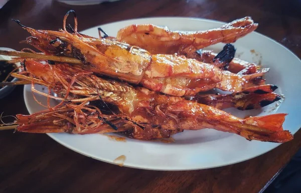 Honey spiced grilled prawns, a typical Indonesian seafood dish that has a savory and sweet taste that is perfectly balanced with a delicious aroma. Beautifully served in a restaurant.