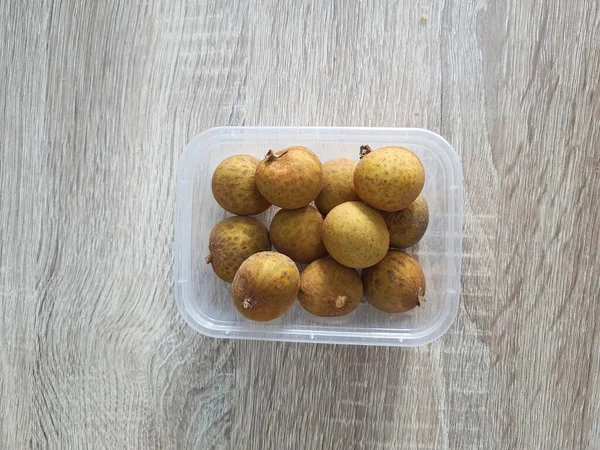 Complementary food supplies for meal box children, in the form of fruit. A small plastic box containing longans fruit. Contains lots of vitamins and antioxidants.
