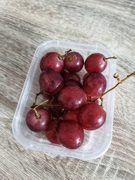 Complementary food supplies for meal box children, in the form of fruit. A small plastic box containing grapes fruit. Contains lots of vitamins and antioxidants.