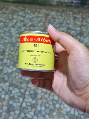 Merkez Java, Endonezya Ekim 2022. Aica Aibon yapıştırıcısını tutan bir el. Yüksek kalite çok amaçlı yapıştırıcıları yüksek yapışkan güç ve ısıya, suya ve neme karşı mükemmel dirençle kullanmak çok kolaydır..