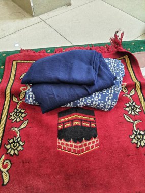 Batı Java, Endonezya Temmuz 2022. Kadınlar için dua araçları ya da katlanmış ve ofis dua odasında biraz dağınık görünen mukenler. Birkaç tane de seccade var..