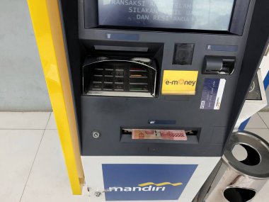 Cakarta, Endonezya Temmuz 2022. Otomatik Teller Machine 'den ya da Bank Mandiri' den birkaç yüz bin rupiah 'lık banknot geldi. Bank Mandiri Endonezya 'nın en büyük bankalarından biridir..