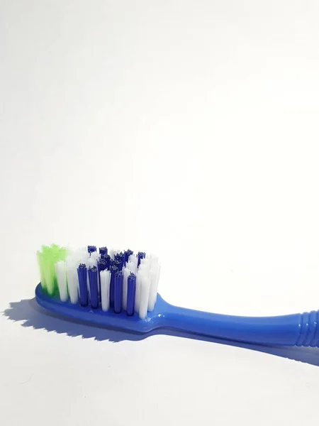 数回使用されているプラスチック歯ブラシの隔離された白い写真 この歯ブラシは青と緑 白と青で構成されたブラシ付きハンドルを持っています — ストック写真