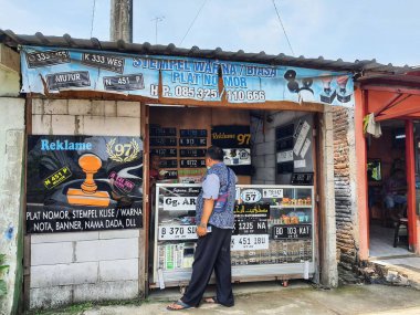 Jepara, Endonezya Kasım 2022. Pul ve plaka dükkanında koşullar. Bu dükkan pul yapmak, plaka yapmak ve araba veya motosiklet plakası takmak için hizmet sunar..