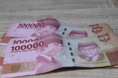 Birkaç yüz bin rupiah banknot ahşap bir masaya yerleştirildi..