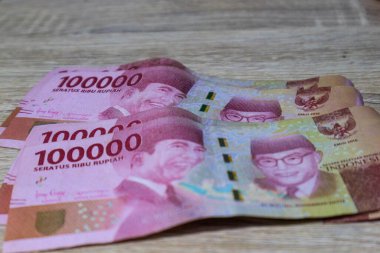 Birkaç yüz bin rupiah banknot ahşap bir masaya yerleştirildi..