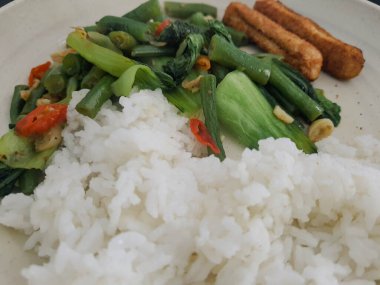 Kahvaltı, öğle yemeği ya da akşam yemeği için basit bir ev yemeği. Kızarmış nugget ve pilav ile sotelenmiş nohut ve pokcoy..