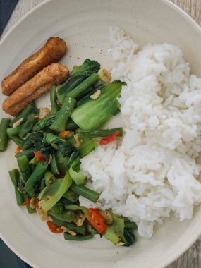 Kahvaltı, öğle yemeği ya da akşam yemeği için basit bir ev yemeği. Kızarmış nugget ve pilav ile sotelenmiş nohut ve pokcoy..