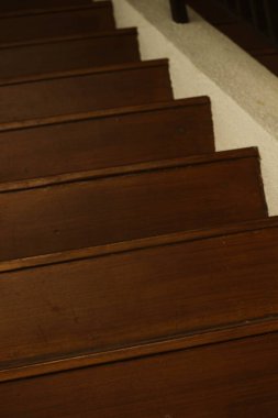 Ahşap merdivenler, bir binada ahşap korkuluklar. Bu tahtanın kullanımı gölgeli, sıcak ve rahat bir atmosfer etkisi yaratıyor..