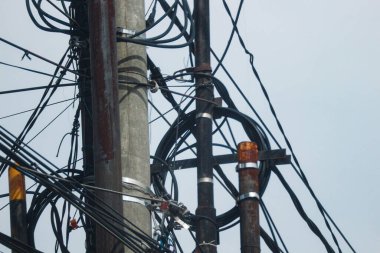 Photo of messy electric poles and power lines in Indonesia.