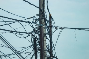 Photo of messy electric poles and power lines in Indonesia.