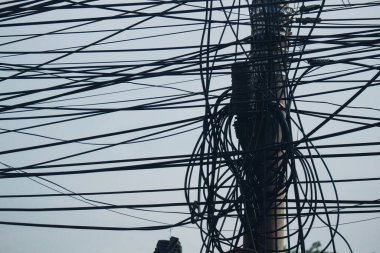 Photo of messy electric poles and power lines in Indonesia.