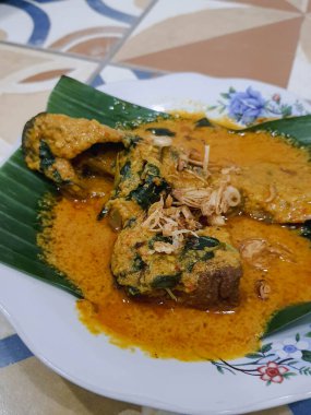 Muz yapraklı bir tabakta yayın balığı mangut servisi yapılır. Pirincin üstüne kızarmış soğan serpilmiş. Yendiğinde tadı daha lezzetli olsun diye..