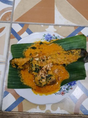 Muz yapraklı bir tabakta yayın balığı mangut servisi yapılır. Pirincin üstüne kızarmış soğan serpilmiş. Yendiğinde tadı daha lezzetli olsun diye..