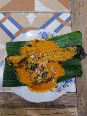 Muz yapraklı bir tabakta yayın balığı mangut servisi yapılır. Pirincin üstüne kızarmış soğan serpilmiş. Yendiğinde tadı daha lezzetli olsun diye..