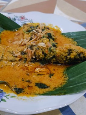 Muz yapraklı bir tabakta yayın balığı mangut servisi yapılır. Pirincin üstüne kızarmış soğan serpilmiş. Yendiğinde tadı daha lezzetli olsun diye..