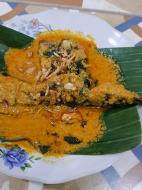 Muz yapraklı bir tabakta yayın balığı mangut servisi yapılır. Pirincin üstüne kızarmış soğan serpilmiş. Yendiğinde tadı daha lezzetli olsun diye..