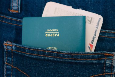 Temmuz 2022 'de Endonezya. Endonezya pasaportu ve pantolon cebinde Filipinler Havayolları uçuş kartı. Bu fotoğraf yurt dışına seyahat etmenin bir göstergesi olarak uygundur..