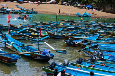 Yogyakarta, Endonezya Ekim 2022. Baron sahilinin tadını çıkaran yerli turistler, Gunung Kidul. Bu sahili turlamak için mavi bir tekneye bindiler..