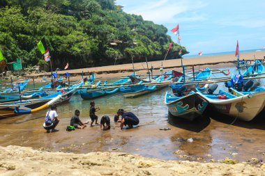 Yogyakarta, Endonezya Ekim 2022. Baron sahilinin tadını çıkaran yerli turistler, Gunung Kidul. Bu sahili turlamak için mavi bir tekneye bindiler..