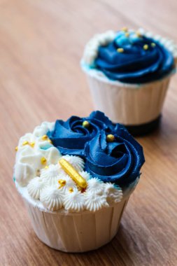 Lüks ve zarif kekler, beyaz kremalı ve lacivert üzerine altın serpiştirilmiş. Tatlı ve kremalı bir tadı var..