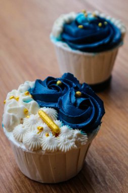 Lüks ve zarif kekler, beyaz kremalı ve lacivert üzerine altın serpiştirilmiş. Tatlı ve kremalı bir tadı var..