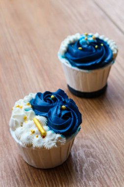 Lüks ve zarif kekler, beyaz kremalı ve lacivert üzerine altın serpiştirilmiş. Tatlı ve kremalı bir tadı var..