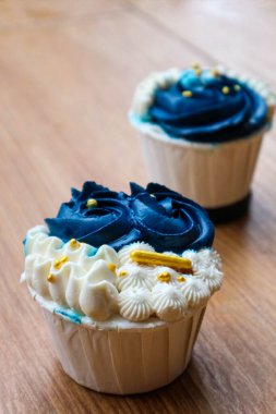 Lüks ve zarif kekler, beyaz kremalı ve lacivert üzerine altın serpiştirilmiş. Tatlı ve kremalı bir tadı var..