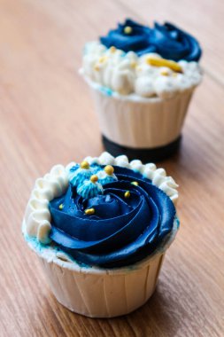 Lüks ve zarif kekler, beyaz kremalı ve lacivert üzerine altın serpiştirilmiş. Tatlı ve kremalı bir tadı var..