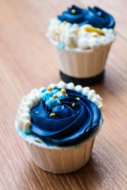 Lüks ve zarif kekler, beyaz kremalı ve lacivert üzerine altın serpiştirilmiş. Tatlı ve kremalı bir tadı var..