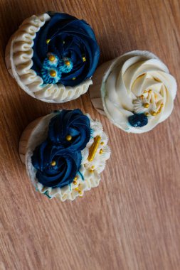 Lüks ve zarif kekler, beyaz kremalı ve lacivert üzerine altın serpiştirilmiş. Tatlı ve kremalı bir tadı var..