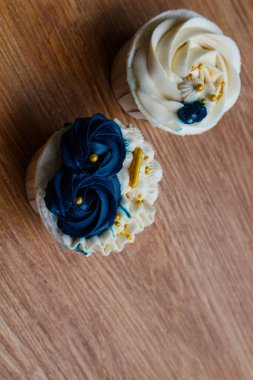 Lüks ve zarif kekler, beyaz kremalı ve lacivert üzerine altın serpiştirilmiş. Tatlı ve kremalı bir tadı var..