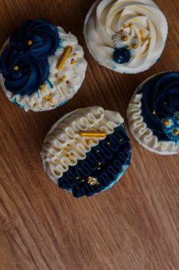 Lüks ve zarif kekler, beyaz kremalı ve lacivert üzerine altın serpiştirilmiş. Tatlı ve kremalı bir tadı var..