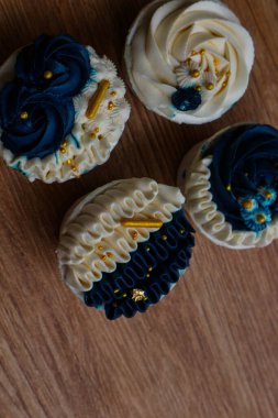 Lüks ve zarif kekler, beyaz kremalı ve lacivert üzerine altın serpiştirilmiş. Tatlı ve kremalı bir tadı var..