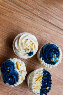 Lüks ve zarif kekler, beyaz kremalı ve lacivert üzerine altın serpiştirilmiş. Tatlı ve kremalı bir tadı var..