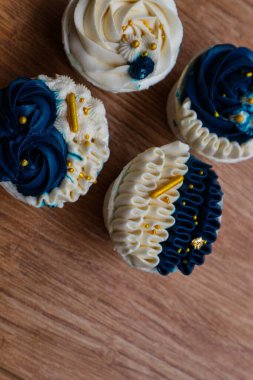 Lüks ve zarif kekler, beyaz kremalı ve lacivert üzerine altın serpiştirilmiş. Tatlı ve kremalı bir tadı var..