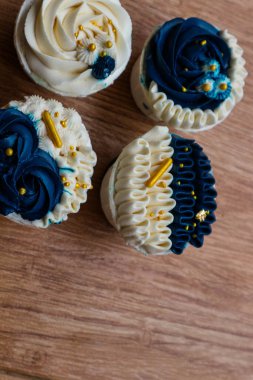 Lüks ve zarif kekler, beyaz kremalı ve lacivert üzerine altın serpiştirilmiş. Tatlı ve kremalı bir tadı var..