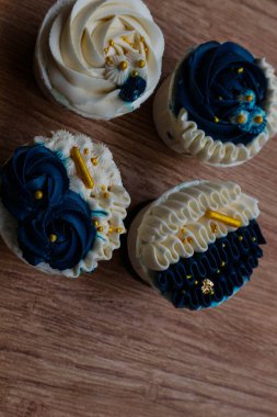 Lüks ve zarif kekler, beyaz kremalı ve lacivert üzerine altın serpiştirilmiş. Tatlı ve kremalı bir tadı var..