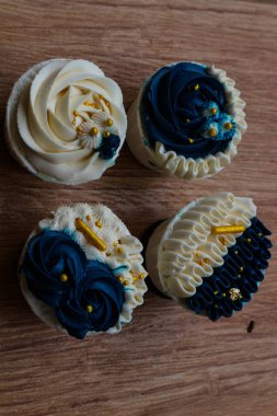 Lüks ve zarif kekler, beyaz kremalı ve lacivert üzerine altın serpiştirilmiş. Tatlı ve kremalı bir tadı var..
