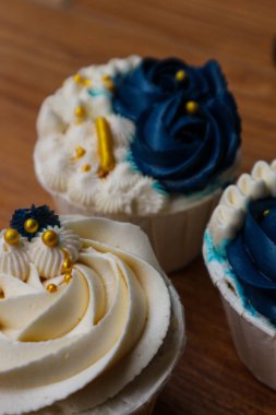 Lüks ve zarif kekler, beyaz kremalı ve lacivert üzerine altın serpiştirilmiş. Tatlı ve kremalı bir tadı var..