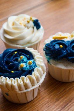 Lüks ve zarif kekler, beyaz kremalı ve lacivert üzerine altın serpiştirilmiş. Tatlı ve kremalı bir tadı var..