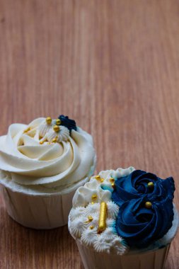Lüks ve zarif kekler, beyaz kremalı ve lacivert üzerine altın serpiştirilmiş. Tatlı ve kremalı bir tadı var..