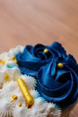Lüks ve zarif kekler, beyaz kremalı ve lacivert üzerine altın serpiştirilmiş. Tatlı ve kremalı bir tadı var..