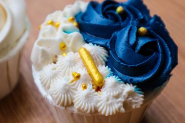 Lüks ve zarif kekler, beyaz kremalı ve lacivert üzerine altın serpiştirilmiş. Tatlı ve kremalı bir tadı var..