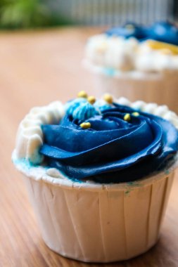 Lüks ve zarif kekler, beyaz kremalı ve lacivert üzerine altın serpiştirilmiş. Tatlı ve kremalı bir tadı var..