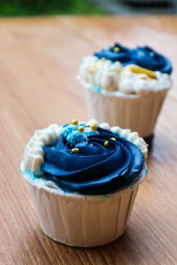 Lüks ve zarif kekler, beyaz kremalı ve lacivert üzerine altın serpiştirilmiş. Tatlı ve kremalı bir tadı var..