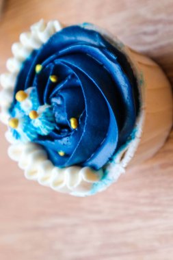 Lüks ve zarif kekler, beyaz kremalı ve lacivert üzerine altın serpiştirilmiş. Tatlı ve kremalı bir tadı var..